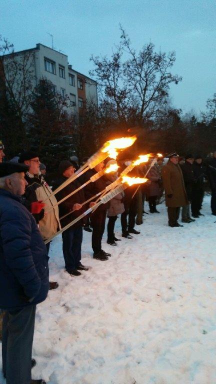 Uczestnicy trzymający zapalone pochodnie.