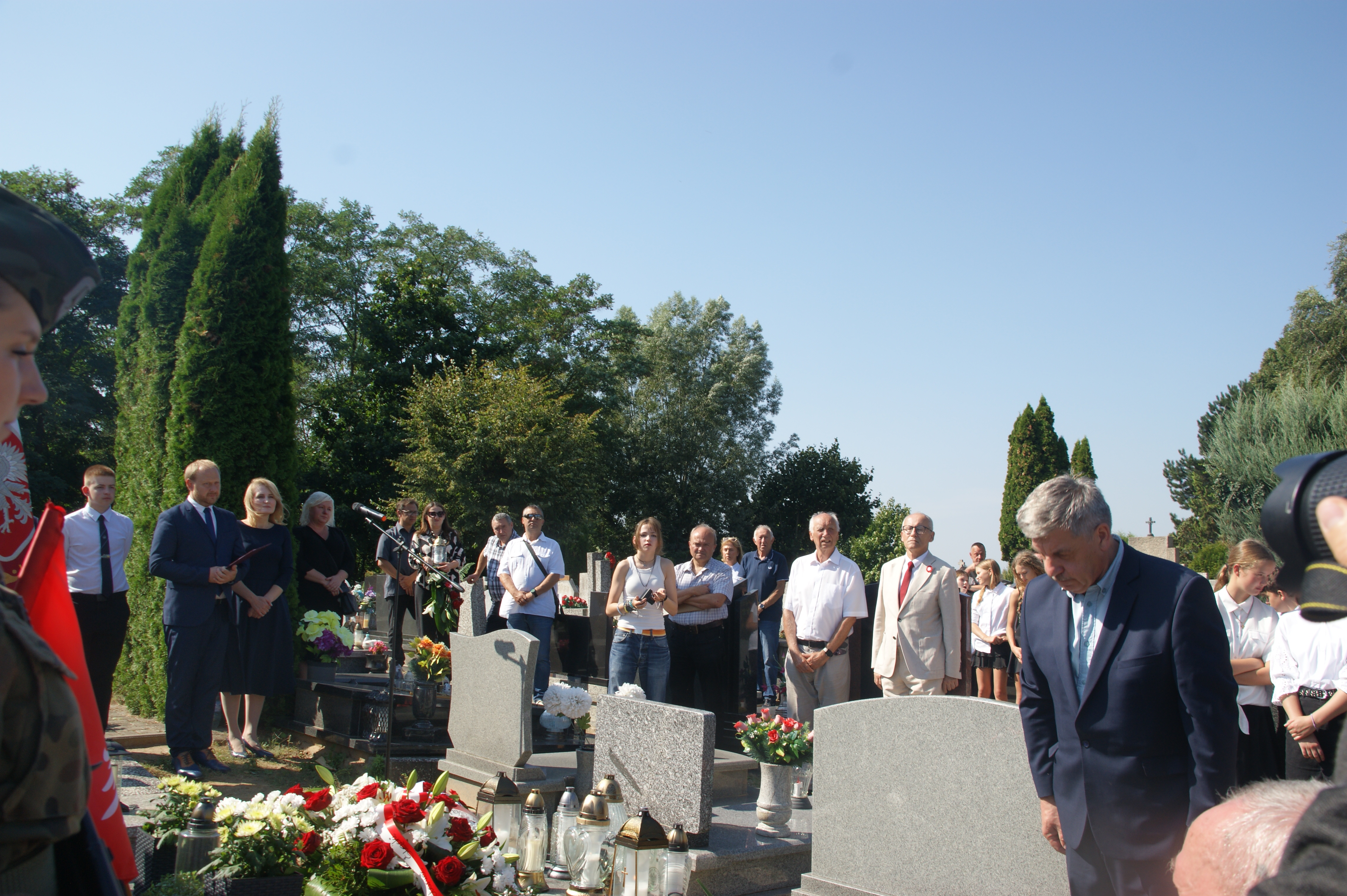 Ludzie stojący przy grobie