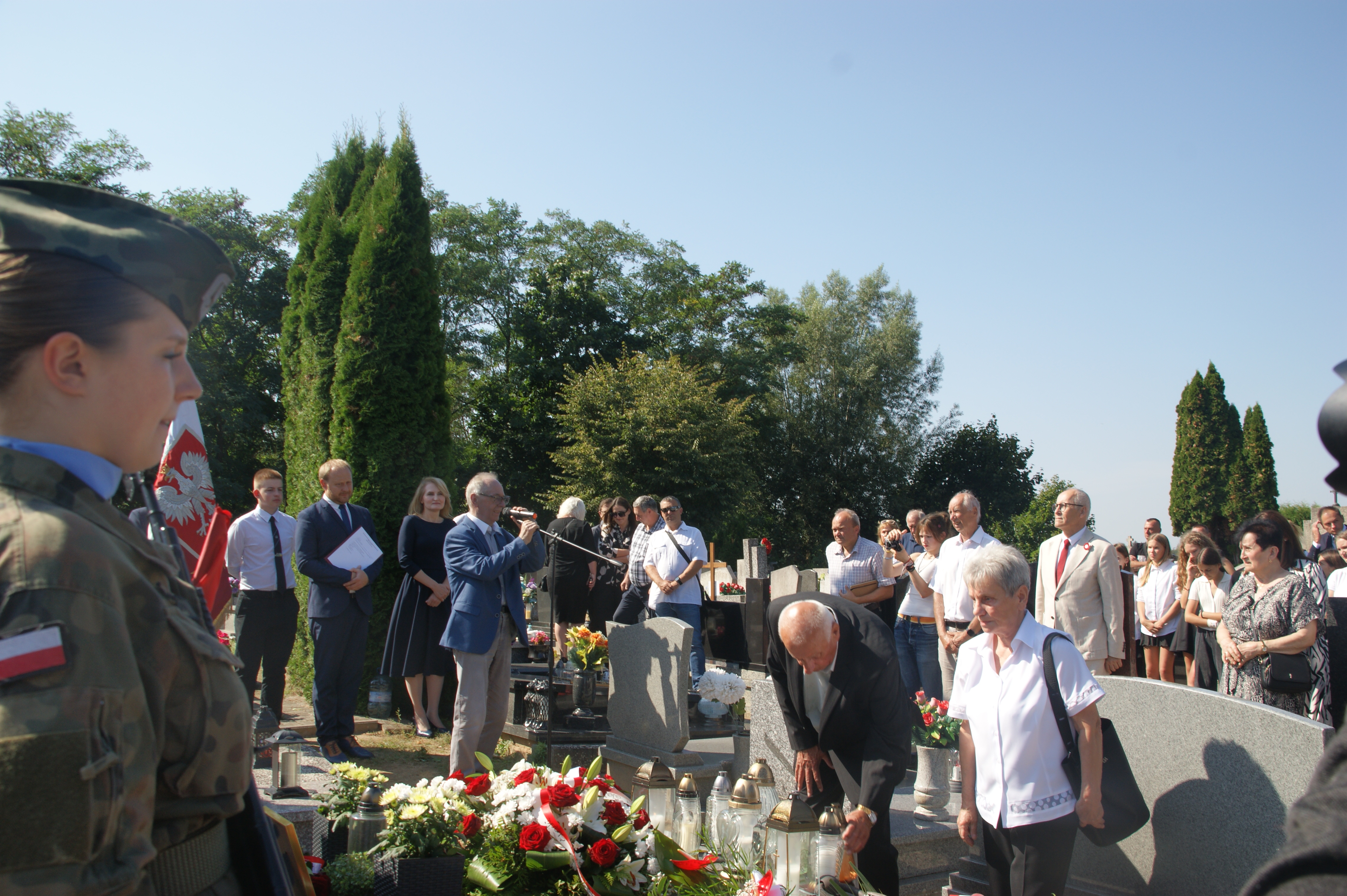 Ludzie stojący przy grobie