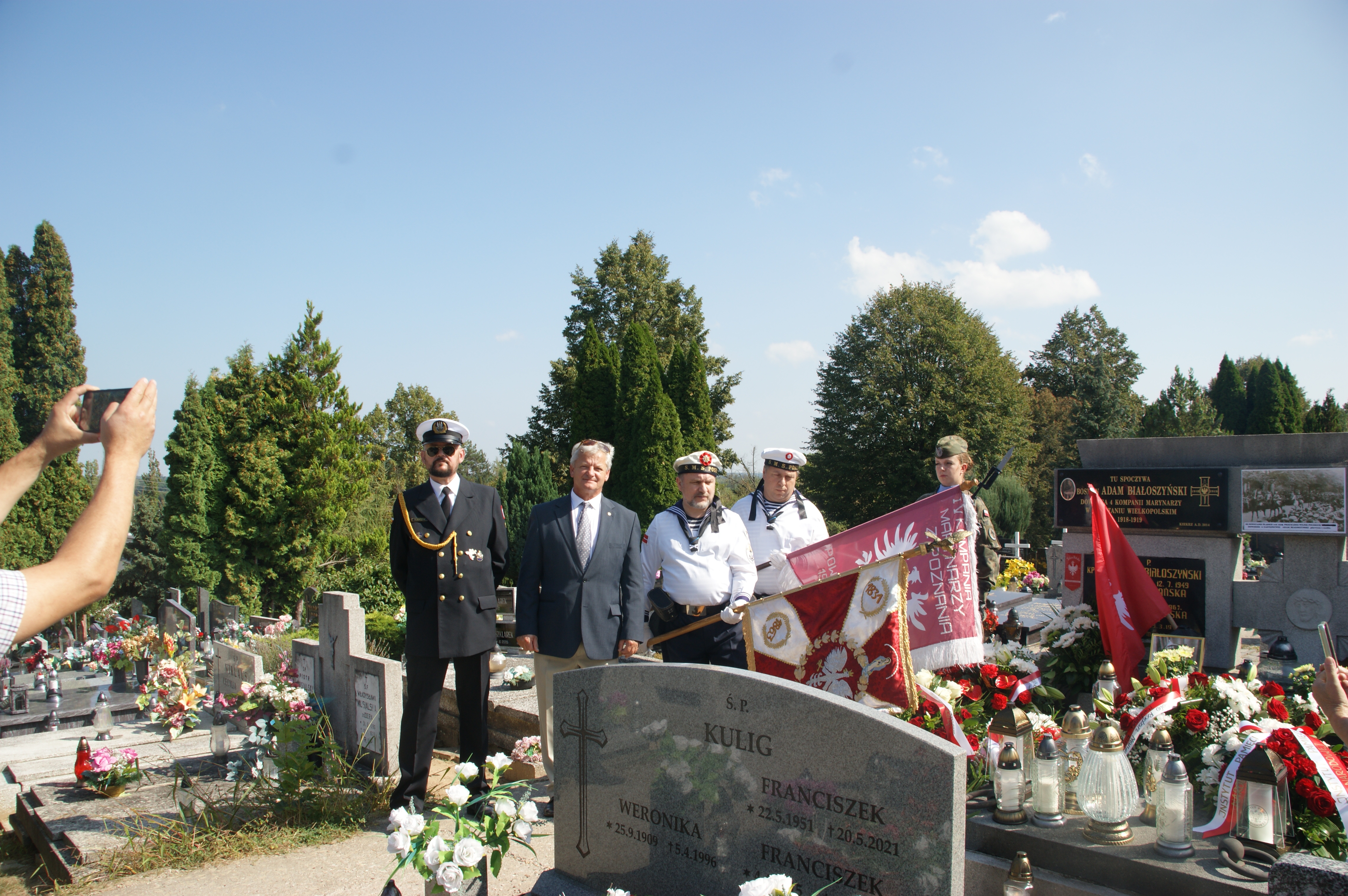 Ludzie stojący przy grobie
