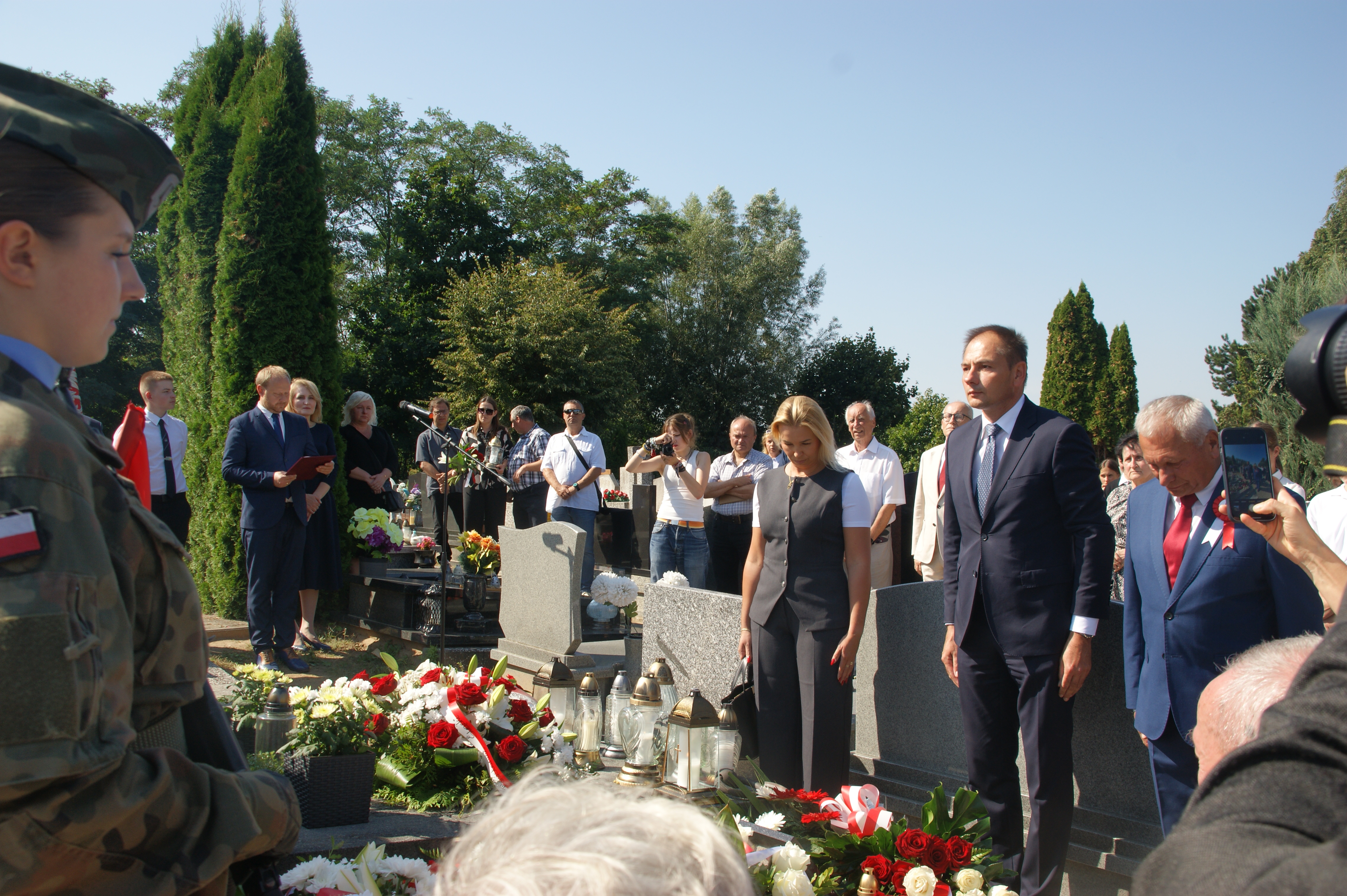 Ludzie stojący przy grobie