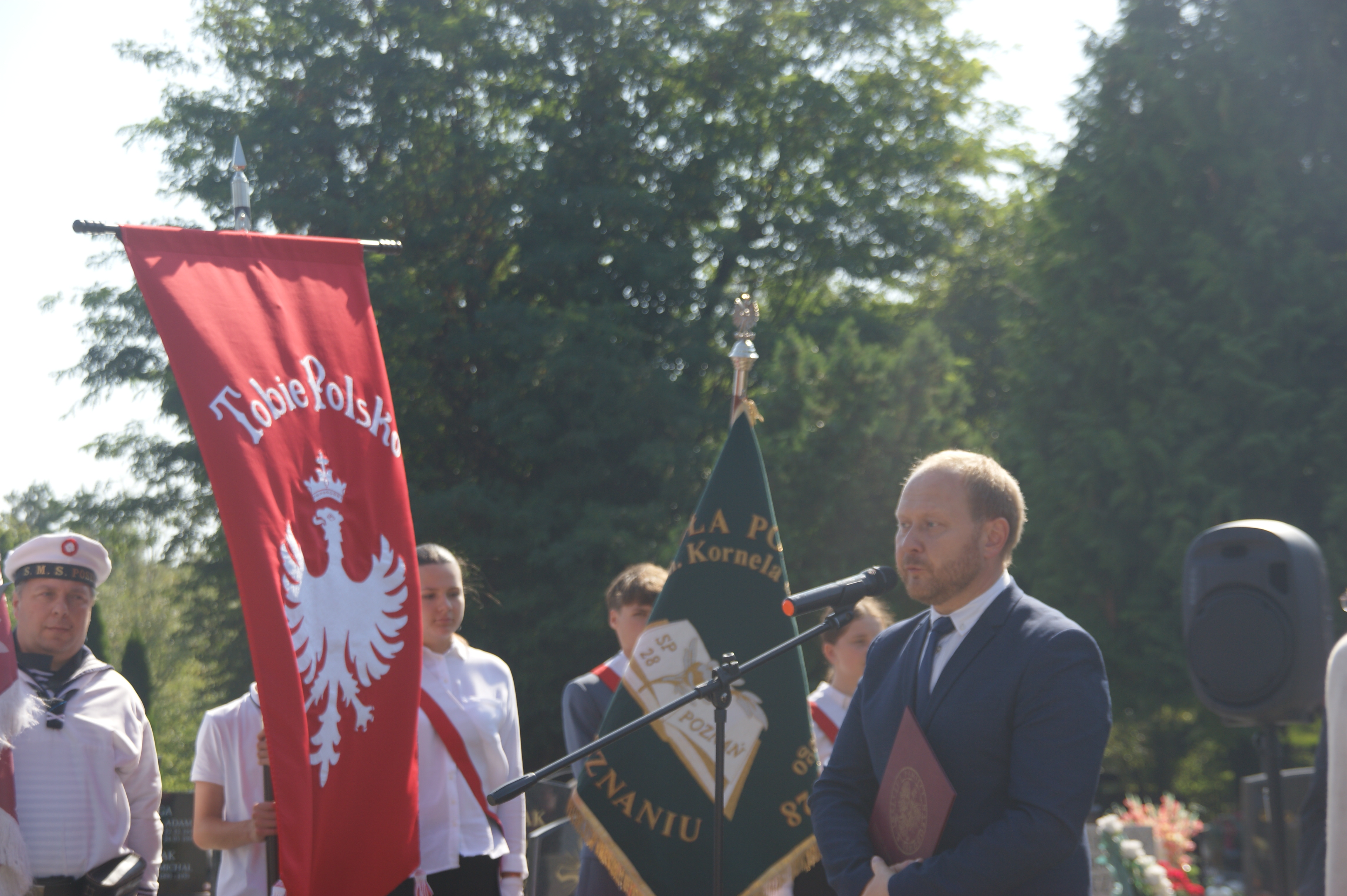 Ludzie stojący przy grobie